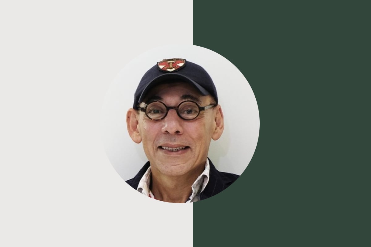 Portrait of Prof. Bakr Rabie in a dark cap and round tortoiseshell glasses, set against a deep green field.